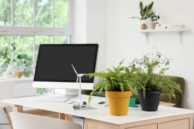 Ofiste bilgisayar monitörlü, santralli ve rüzgar türbinli mühendis işyeri