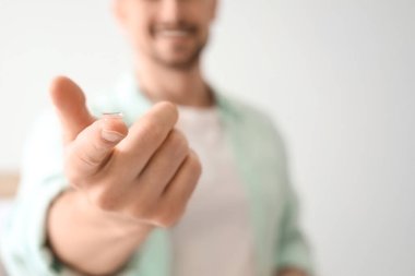 Yatak odasında lensli genç adam, yakın plan.