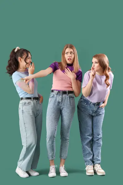 stock image Young women gossiping on green background