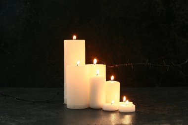 Siyah arka planda dikenli telle mum yakmak. Anma Günü