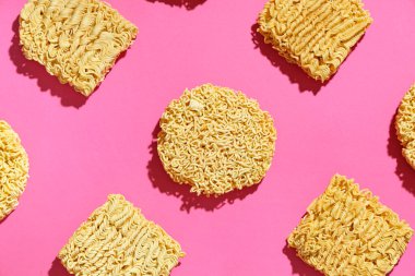 Pembe arka planda çiğ erişte.