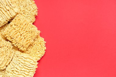 Kırmızı arkaplanda çiğ erişte.