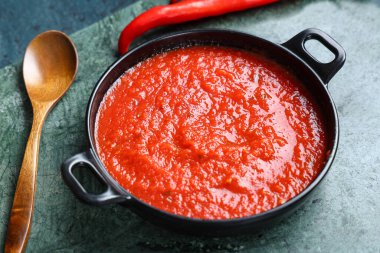 Koyu arkaplanda acı biberli domates sosu kızartma tavası.