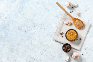 Bir kase dijon hardalı, biberli ve sarımsaklı beyaz arka plan.