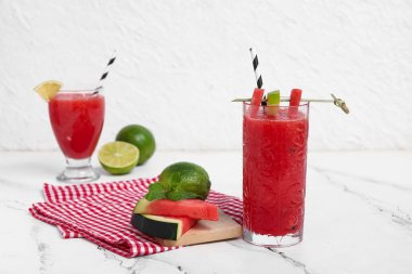 Beyaz arka planda limonlu ve naneli taze karpuz suyu.