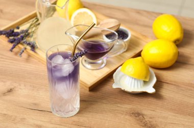 Tahta masada limon ve meyve sıkacağıyla taze lavantalı limonata.