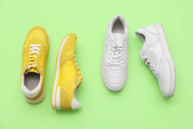 Yeşil arka planda farklı tarz erkek ayakkabıları.