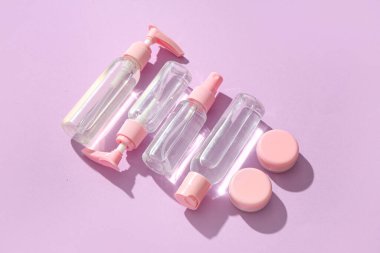 Leylak arka planında farklı seyahat kozmetik ürünleri seti