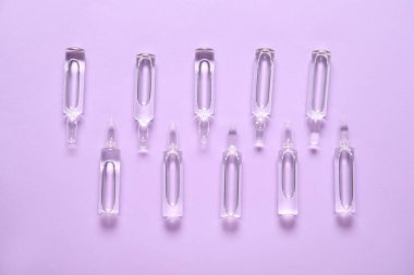 Mor arkaplandaki cam ampules