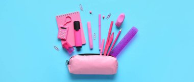 Açık mavi arka planda farklı okul kırtasiyesine sahip kalem kutusu, üst görünüm