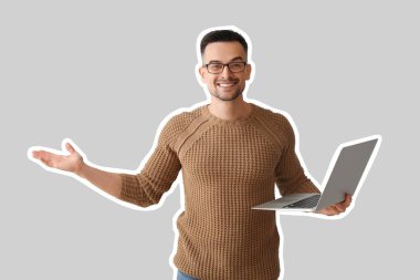 Gri arka planda dizüstü bilgisayarı olan erkek programcı