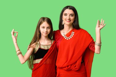 Anne ve kızı yeşil arka planda sari giymişler. Divaly kutlaması