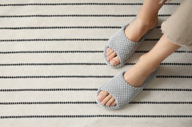 Evde terlik giymiş genç bir kadın, yakın plan.