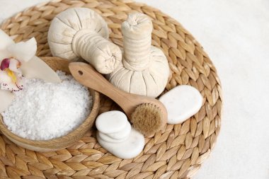 Bitki torbalı deniz tuzu, spa taşları ve beyaz arka planda orkide çiçeği.