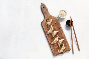 Kızarmış Japon gyoza ve beyaz arka planda bir kase soya soslu ahşap tahta tahta.