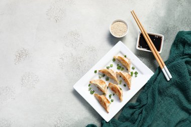 Kızarmış Japon gyoza tabağı ve arka planda soya sosu.