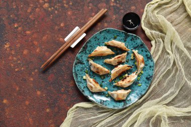 Kızarmış Japon gyoza tabağı ve koyu arkaplanda soya sosu.