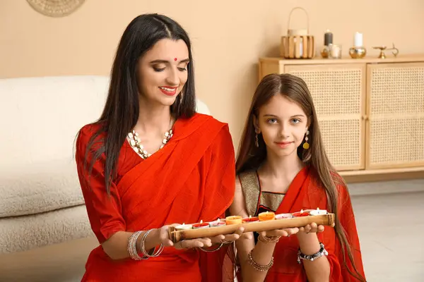 stock image Beautiful mother with her daughter holding candles at home. Divaly celebration