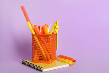 Leylak arka planında okul malzemeleri olan kalem tutacağı.