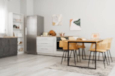 Mutfaktaki yemek masasında buzdolabı ve tezgah var. Bulanık görünüm