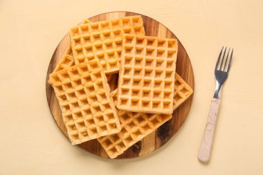 Sarı arka planda lezzetli Belçika waffle 'ları olan ahşap tahta tahta.