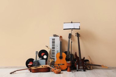 Different musical instruments near beige wall clipart