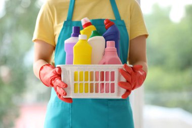 Pencerenin yanında temizlik malzemeleri olan kadın hademe, yakın çekim.