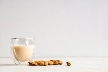 Beyaz arka planda taze badem sütü ve fındık.