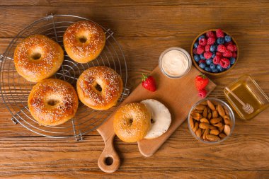 Lezzetli simitlerle, böğürtlenlerle ve ahşap arka planda badem fıstıklarıyla durun.
