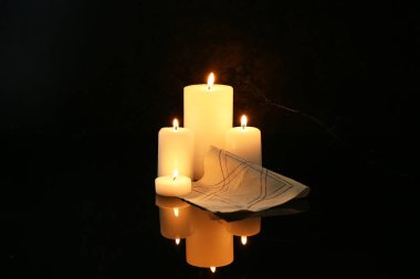 Karanlık arka planda dikenli telli mumlar ve Yahudi rozeti yakmak. Anma Günü