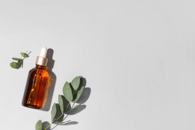 Gri arka planda bir şişe okaliptüs yağı