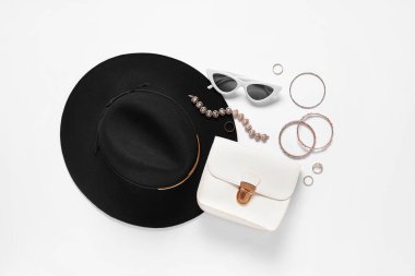 Beyaz arka planda şapka, çanta ve yüzüklerle süslü aksesuarlar. Üst görünüm