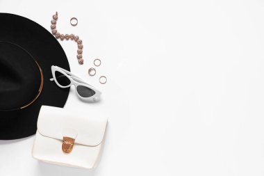 Beyaz arka planda şapka, çanta ve yüzüklerle süslü aksesuarlar. Üst görünüm