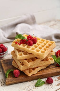 Taze ahududu, kırmızı frenk üzümü ve beyaz ahşap arka planda nane şekerli Belçika waffle 'ları.