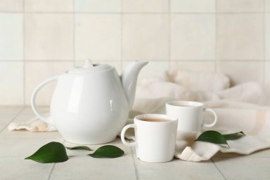 Beyaz fayanslı fincanlar ve çaydanlıklar.