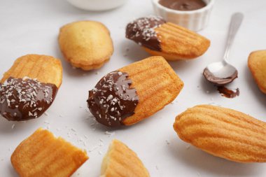 Çikolata kremalı ve beyaz arka planda hindistan cevizi taneli lezzetli kurabiyeler.