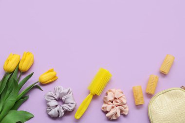 Bigudili makyaj çantası, saç tarağı, ipek tokalar ve mor arka planda lale çiçekleri.