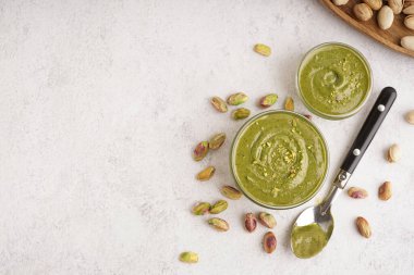 Beyaz arka planda kaşıkla fındık ezmesi.