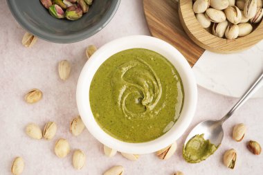 Fıstık ezmeli kase ve pembe grunge arka planda kaşık