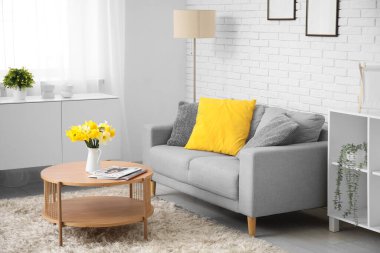 Oturma odasının iç tarafında yastıkları ve kahve masası olan rahat bir kanepe.