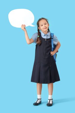 Sırt çantası ve mavi arka planda boş konuşma balonu olan mutlu kız öğrenci.