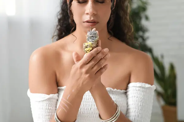 Stock image Beautiful African-American female shaman with herbs performing ritual at home