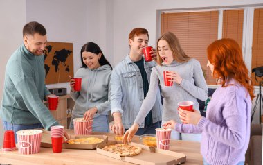 Evde bira ve pizzalı bir grup genç arkadaş.