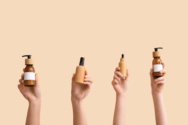 Bej arka planda farklı kozmetik ürünleri tutan kadınlar