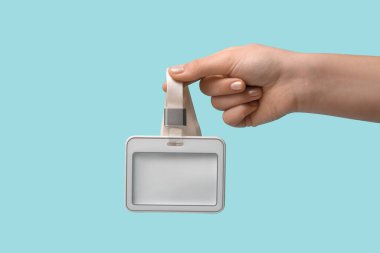 Renk arkaplanına karşı boş rozetli kadın eli, yakın plan