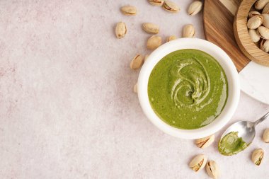 Fıstık ezmeli kase ve pembe grunge arka planda kaşık