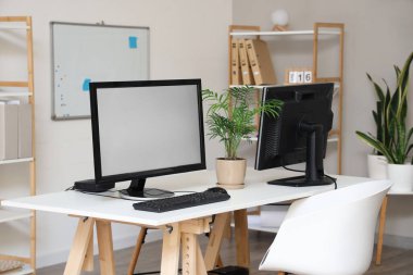 Ofisinde bilgisayar monitörleri olan modern işyeri