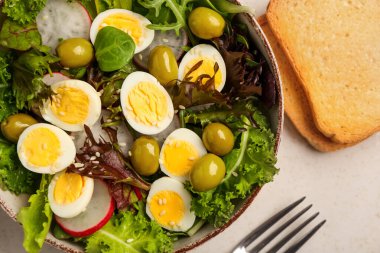 Bir kase lezzetli bıldırcın yumurtası, sebze ve tost, yakın plan.