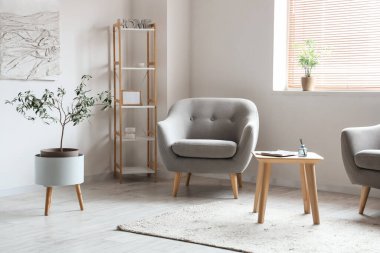 Gri koltuklu ve raf üniteli aydınlık oturma odasının içi.