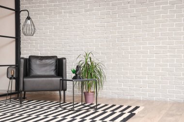 Siyah koltuğu, masası ve lambaları olan modern oturma odasının içinde.